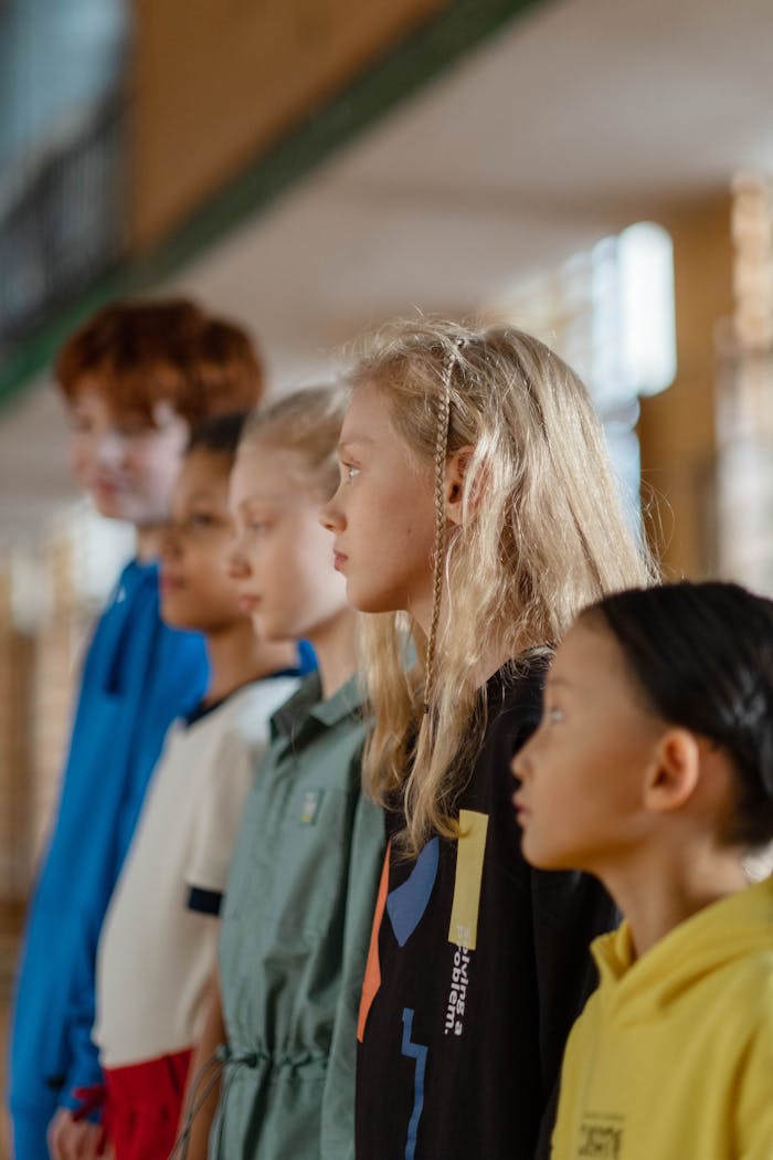 Children lined up in a school setting, showcasing diversity and focus during a classroom activity.
